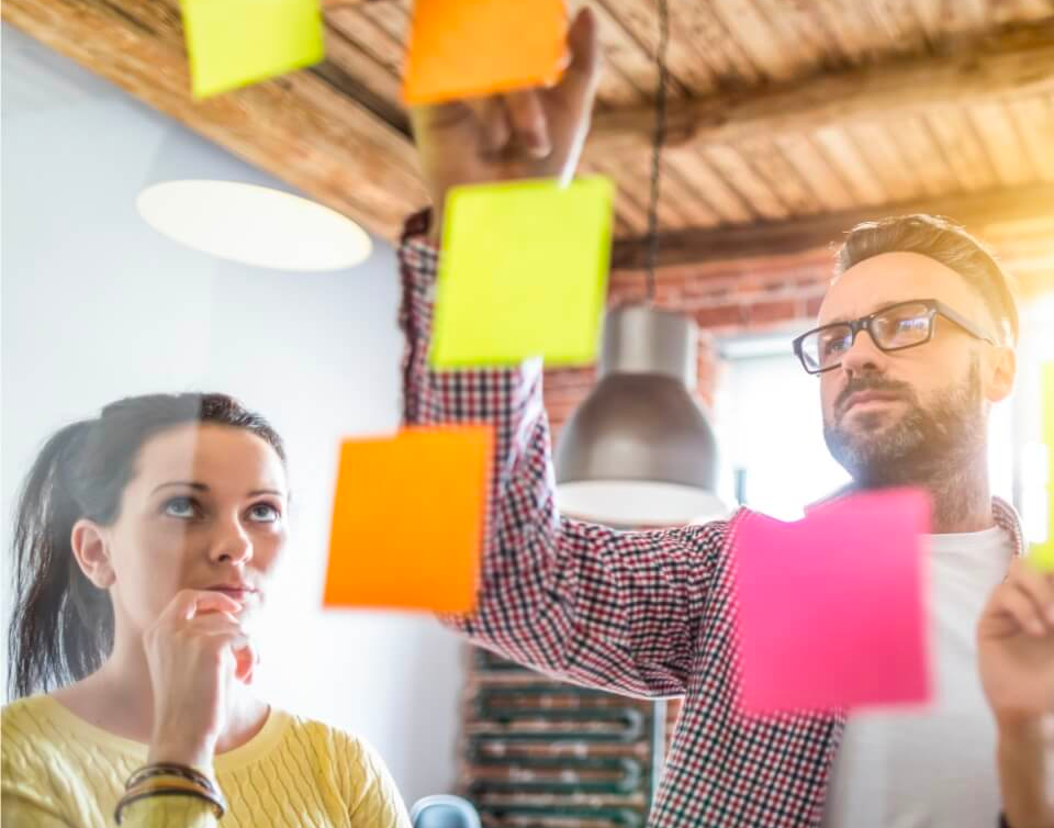 Two teammates brainstorming with post it notes